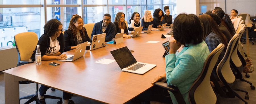 Une dizaine de salariés autour d'une grande table qui travaille et discute entre eux
